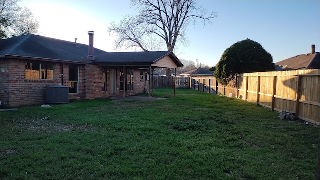 view of yard featuring a fenced backyard and central AC