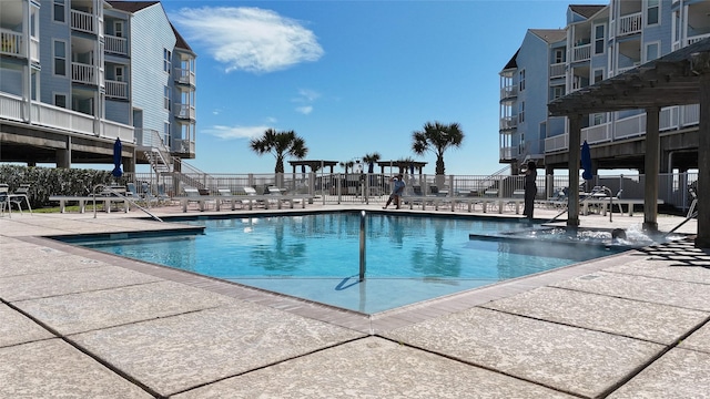 view of swimming pool with a patio and fence