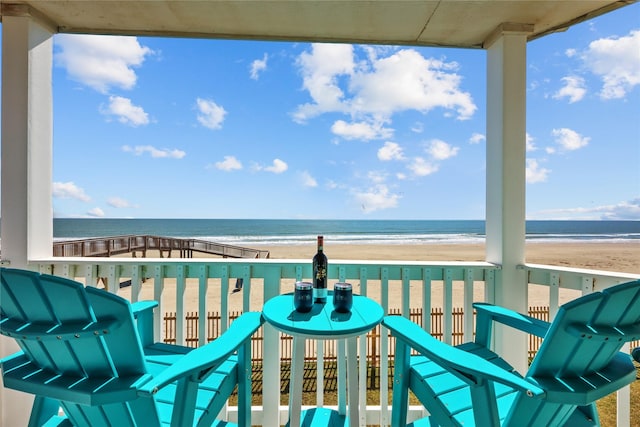 balcony featuring a water view and a beach view