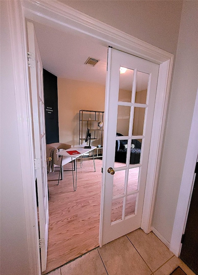 doorway to outside featuring light wood-style floors, french doors, and visible vents