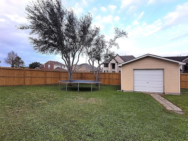 view of yard with a trampoline, an outbuilding, and a fenced backyard