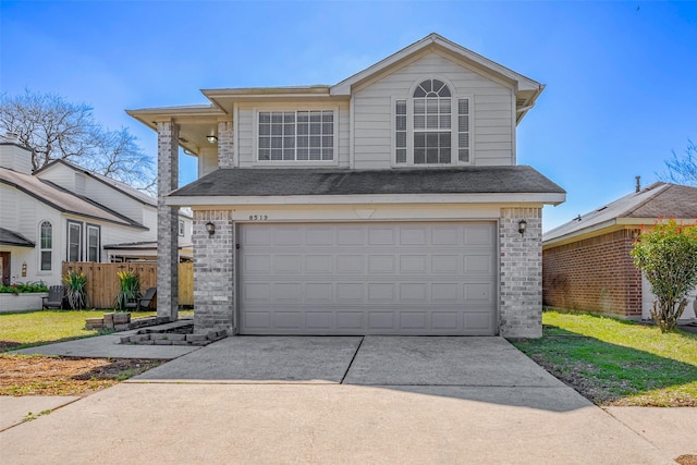 traditional-style home with a garage, concrete driveway, and brick siding