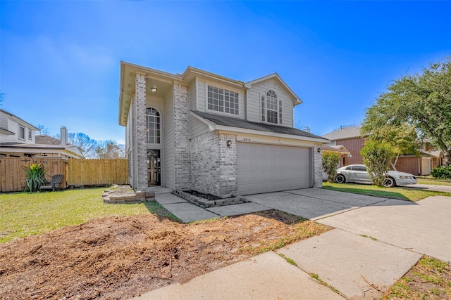 traditional-style home with an attached garage, brick siding, fence, driveway, and a front yard