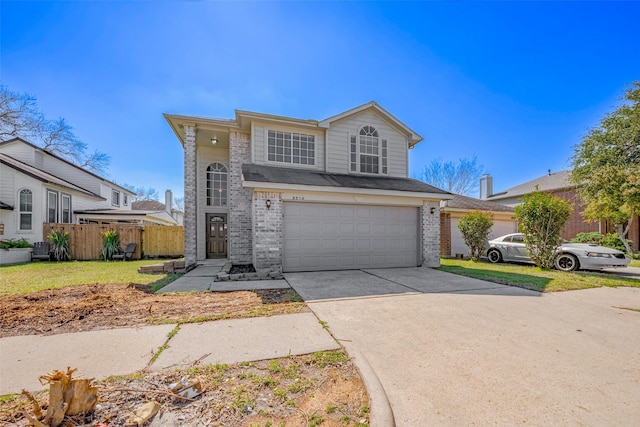 traditional-style home featuring an attached garage, fence, concrete driveway, and brick siding