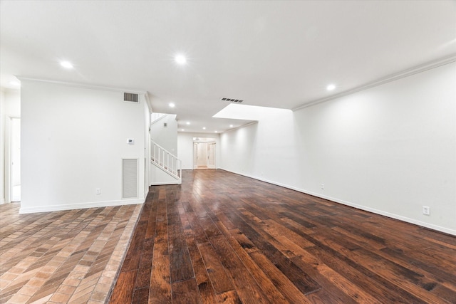 unfurnished living room with visible vents, crown molding, and recessed lighting