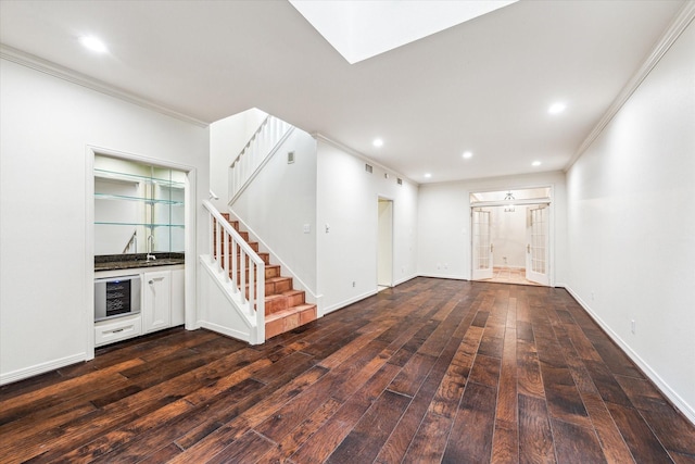 spare room with stairway, ornamental molding, dark wood-style flooring, a sink, and recessed lighting