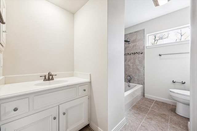 bathroom with tile patterned flooring, baseboards, vanity, and toilet