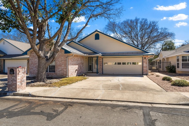 ranch-style home featuring brick siding, fence, driveway, and an attached garage