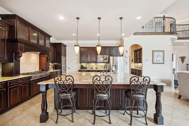 kitchen featuring ornamental molding, appliances with stainless steel finishes, light tile patterned floors, and a large island with sink