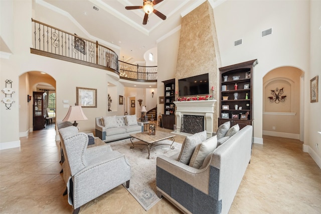 tiled living room with arched walkways, a fireplace, visible vents, and baseboards