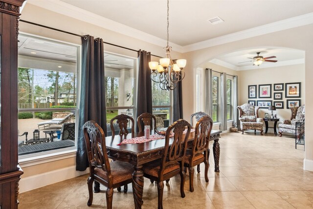 dining room featuring light tile patterned floors, visible vents, arched walkways, baseboards, and ornamental molding