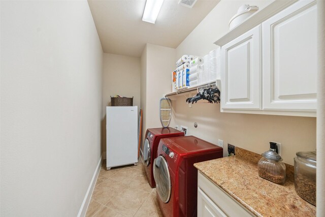 laundry room featuring cabinet space, washer and clothes dryer, baseboards, and light tile patterned flooring