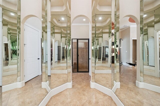 interior space featuring a towering ceiling, tile patterned flooring, and arched walkways