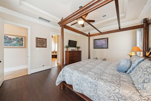 bedroom featuring dark wood-style floors, a raised ceiling, visible vents, and crown molding