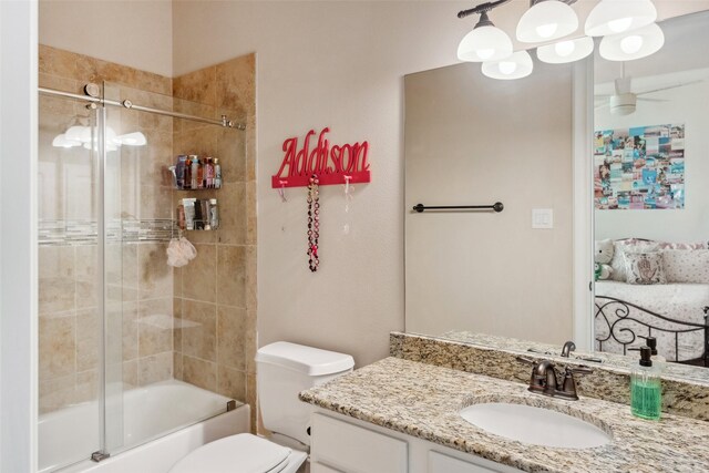 full bathroom featuring combined bath / shower with glass door, vanity, and toilet