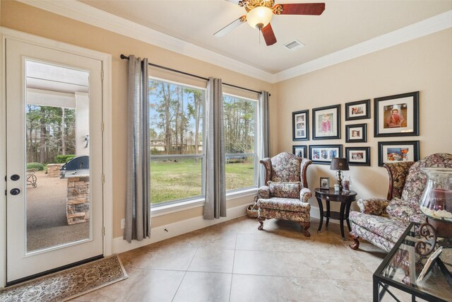 living area featuring crown molding, visible vents, a ceiling fan, baseboards, and tile patterned floors