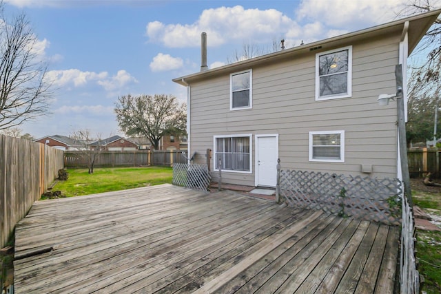 back of house featuring a fenced backyard, a deck, and a lawn