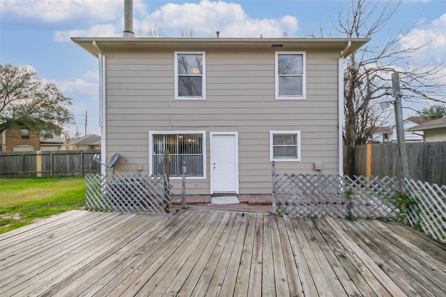 back of house featuring fence private yard, a yard, and a wooden deck