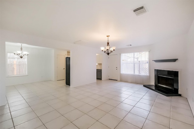 unfurnished living room featuring a chandelier, a fireplace with raised hearth, light tile patterned flooring, and visible vents