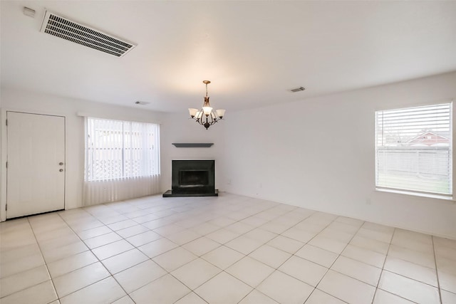 unfurnished living room featuring light tile patterned floors, visible vents, and a wealth of natural light