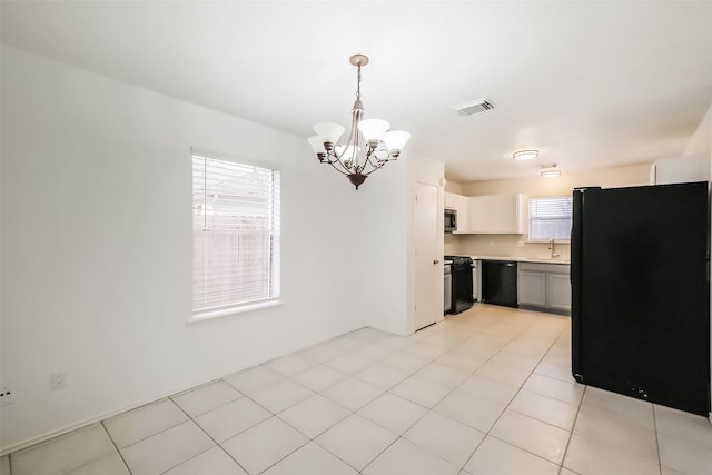 kitchen with a notable chandelier, light countertops, visible vents, a sink, and black appliances