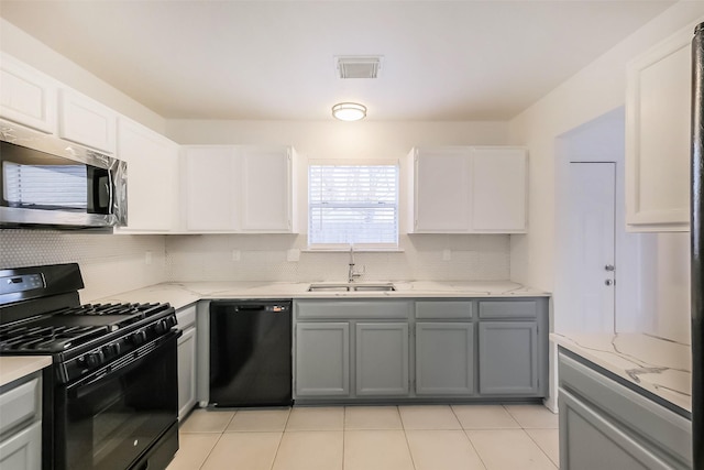 kitchen with visible vents, decorative backsplash, gray cabinets, black appliances, and a sink