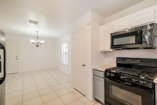 kitchen featuring black gas range, tasteful backsplash, white cabinets, stainless steel microwave, and light countertops