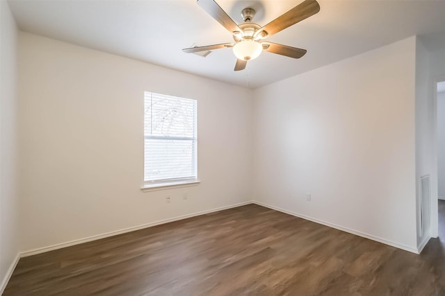 spare room with dark wood-style floors, ceiling fan, and baseboards