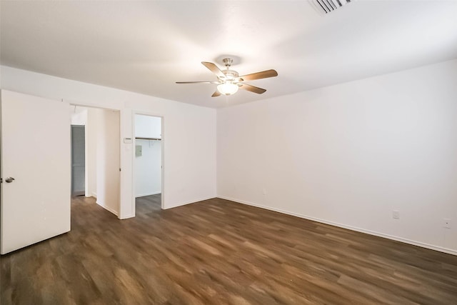 unfurnished bedroom with wood finished floors, visible vents, a ceiling fan, a closet, and a walk in closet