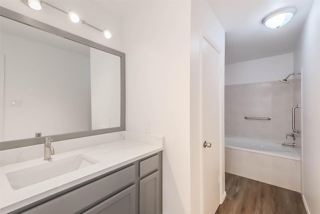 full bathroom with tiled shower / bath combo, wood finished floors, and vanity