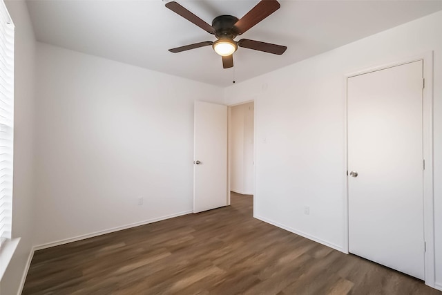 unfurnished bedroom with ceiling fan, wood finished floors, and baseboards