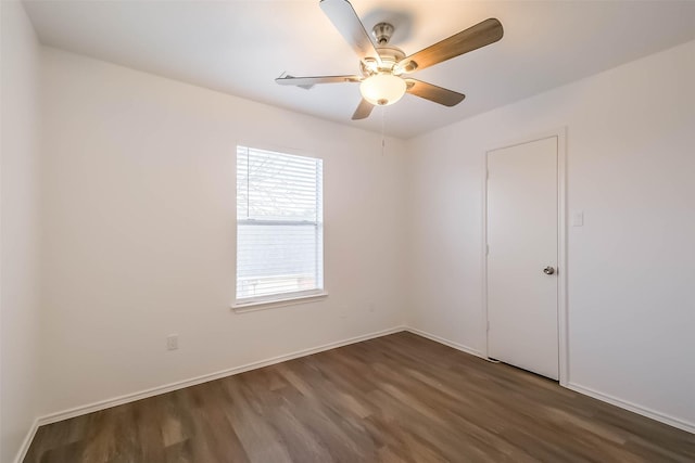 empty room with a ceiling fan, dark wood-style flooring, and baseboards