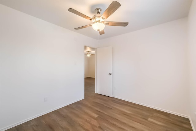 spare room with ceiling fan, baseboards, and wood finished floors