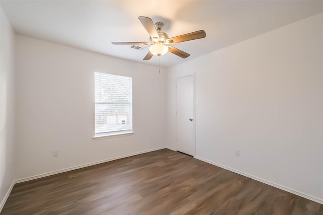 unfurnished room featuring ceiling fan, dark wood finished floors, visible vents, and baseboards