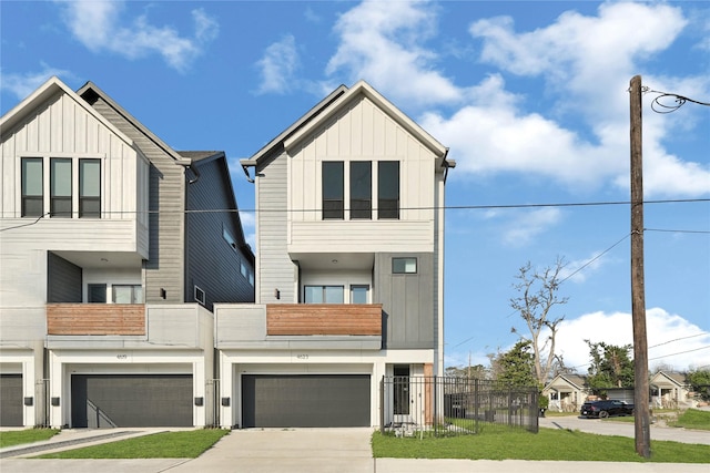 view of front of property with driveway, board and batten siding, an attached garage, and fence