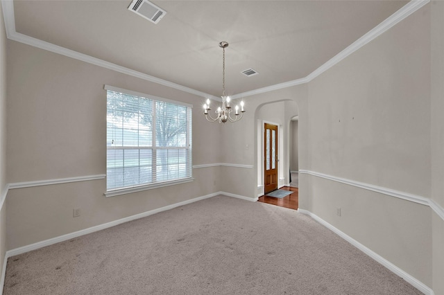 empty room featuring carpet floors, visible vents, arched walkways, and ornamental molding