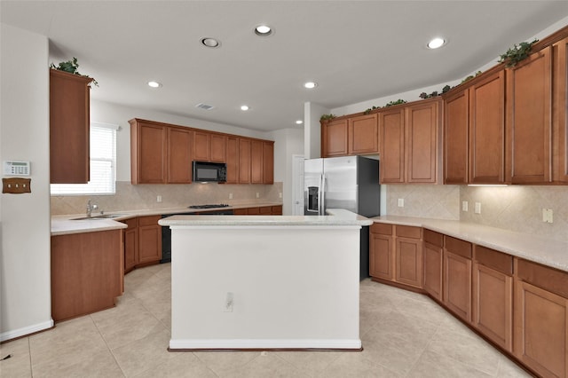 kitchen featuring brown cabinetry, black microwave, and stainless steel refrigerator with ice dispenser