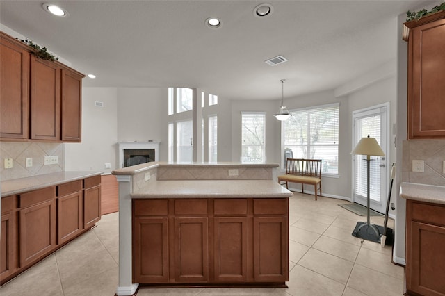 kitchen with visible vents, brown cabinets, and light tile patterned flooring