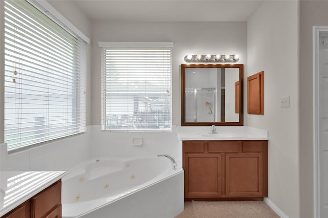 bathroom with a stall shower, a jetted tub, and vanity