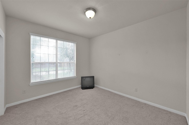 carpeted spare room featuring baseboards