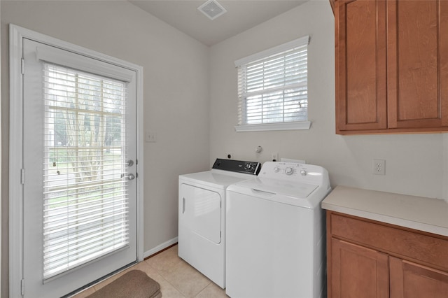 laundry area featuring light tile patterned floors, cabinet space, visible vents, and washer and dryer