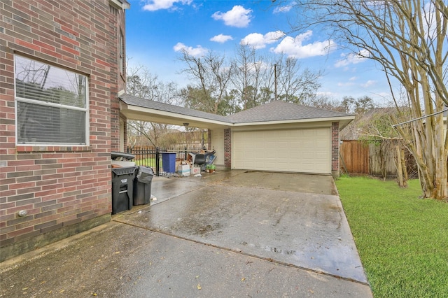 exterior space with a yard, brick siding, fence, and driveway