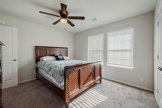 bedroom with a ceiling fan, light colored carpet, visible vents, and baseboards