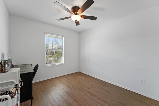 office with wood finished floors, a ceiling fan, and baseboards