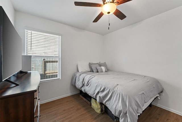 bedroom featuring ceiling fan, baseboards, and wood finished floors