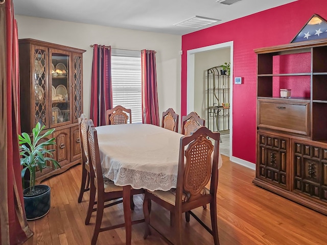 dining area with wood finished floors and visible vents