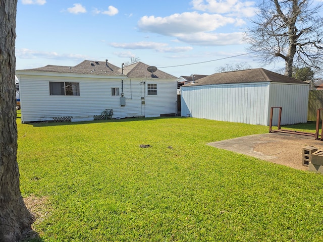 rear view of property with a lawn and an outbuilding