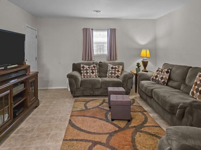 living area with light tile patterned floors, visible vents, and baseboards