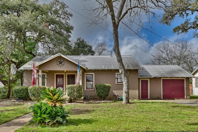 single story home with stucco siding, an attached garage, a front yard, metal roof, and driveway