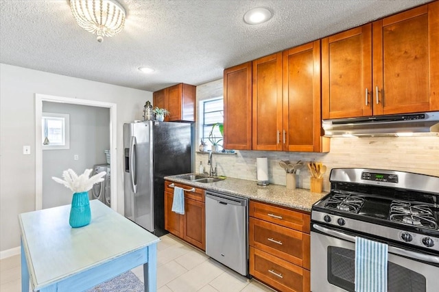 kitchen with under cabinet range hood, plenty of natural light, stainless steel appliances, and a sink